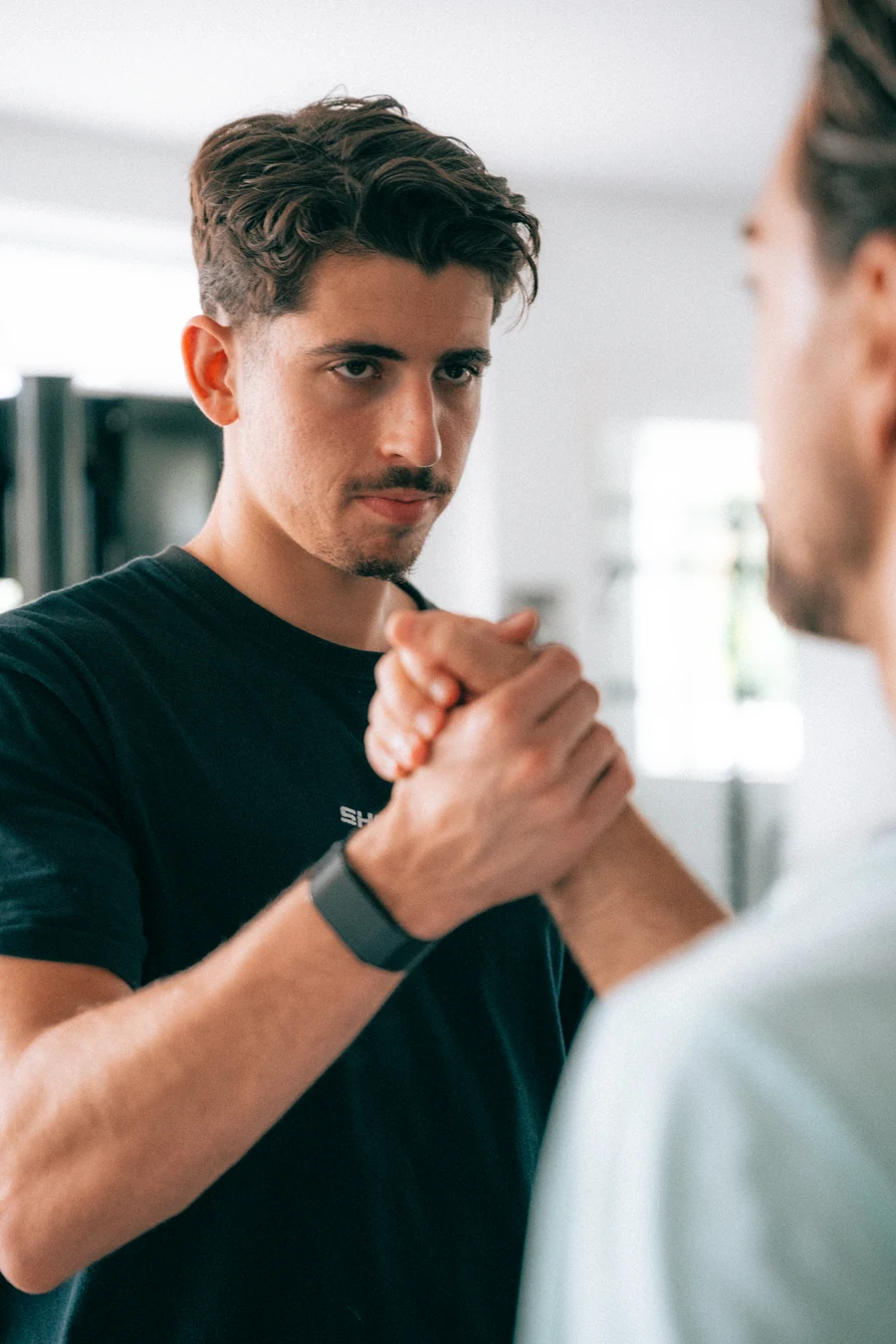 Treinador do ShapeUp a cumprimentar um aluno no estúdio