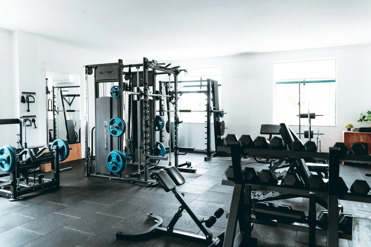 Zona de musculação do estúdio ShapeUp com racks, halteres e bancos